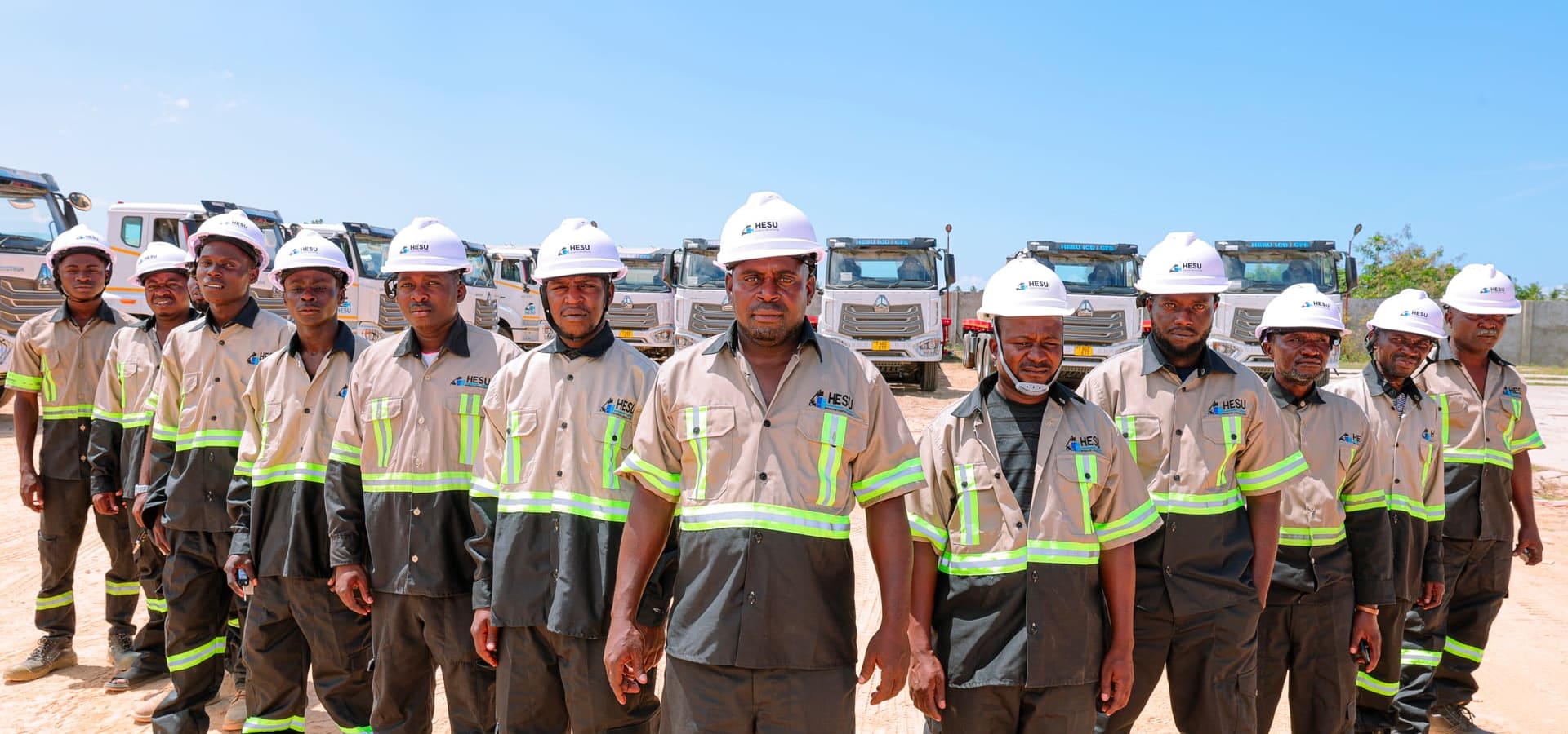 Hesu drivers in uniform standing in front of the truck fleet